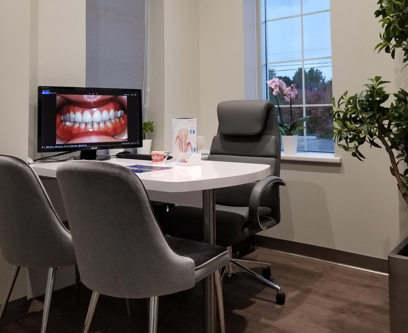 A desk at Lifetime Dental with a monitor display a photo of a patient's teeth.